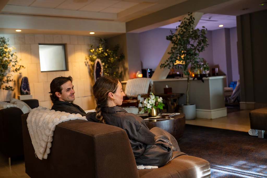 A couple relaxing together in robes inside The Spa at The Peaks lounge